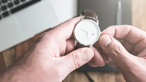 Manos de hombre ajustando un reloj de pulsera Manos de hombre ajustando un reloj de pulsera