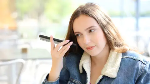 Mujer escuchando un audio desde el teléfono Mujer escuchando un audio desde el teléfono