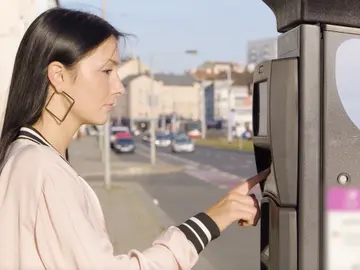 Mujer pagando el aparcamiento Mujer pagando el aparcamiento