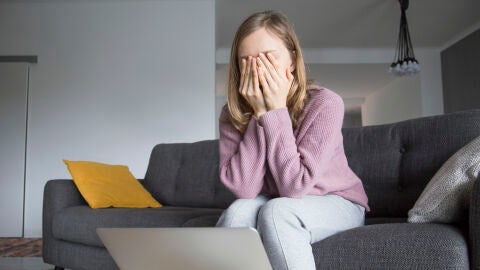 Una mujer triste se cubre la cara con la manos