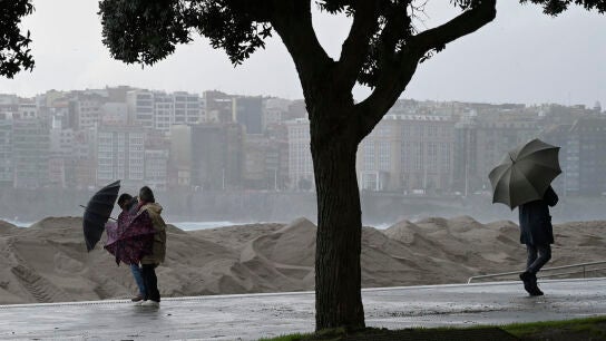 Varias personas se protegen de la lluvia junto a la costa de A Coru&ntilde;a este mi&eacute;rcoles