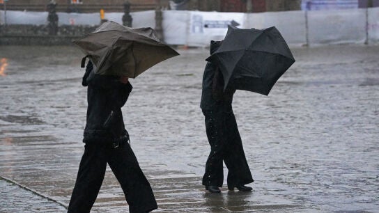 Varias personas intentan sujetar sus paraguas, a 26 de enero de 2026, en Santiago de Compostela, A Coru&ntilde;a, Galicia (Espa&ntilde;a).