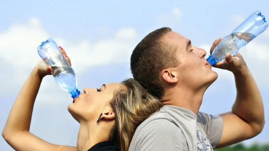 Dos personas bebiendo agua de una botella Dos personas bebiendo agua de una botella