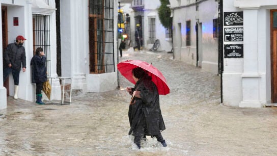Una vecina de Grazalema (C&aacute;diz) camina por una calle inundada debido a las intensas lluvias