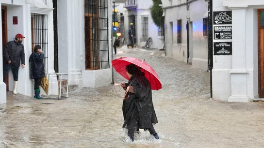 Una vecina de Grazalema (Cádiz) camina por una calle inundada debido a las intensas lluvias Una vecina de Grazalema (Cádiz) camina por una calle inundada debido a las intensas lluvias