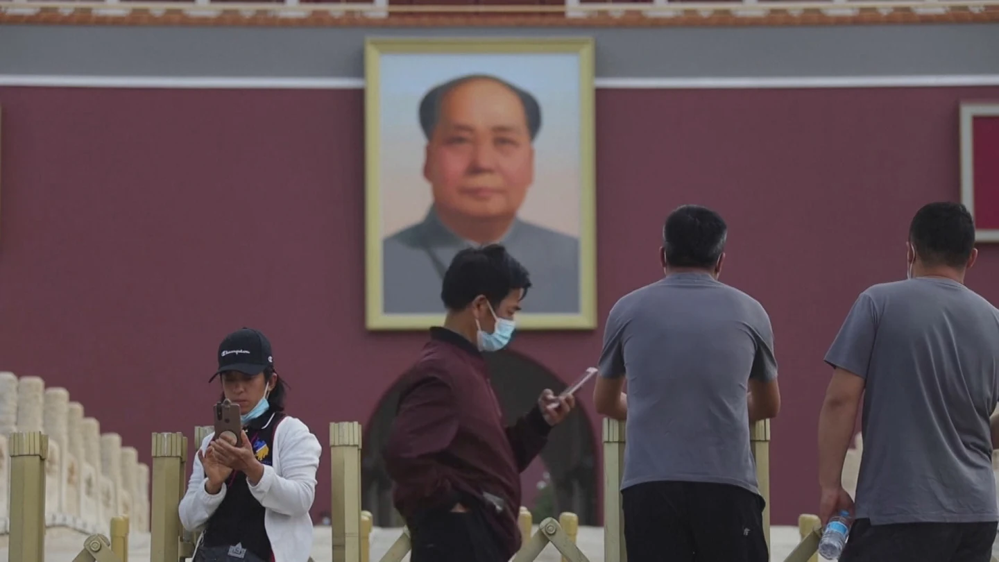 Un joven mira su teléfono bajo la mirada de Mao en Tiananmen, en Pekín. Un joven mira su teléfono bajo la mirada de Mao en Tiananmen, en Pekín.