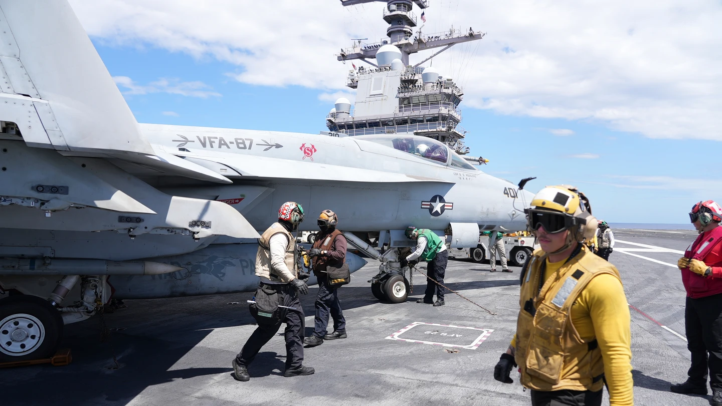 Un oficial de catapulta, a la derecha, pasa junto a un F-18 Super Hornet en la cubierta de vuelo del portaaviones USS Gerald R. Ford durante ejercicios militares en el Mediterráneo Un oficial de catapulta, a la derecha, pasa junto a un F-18 Super Hornet en la cubierta de vuelo del portaaviones USS Gerald R. Ford durante ejercicios militares en el Mediterráneo