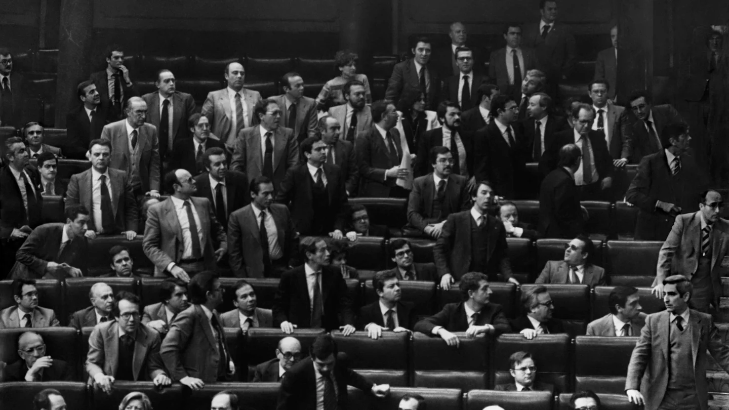 Los diputados se levantan de sus escaños y miran hacia la puerta por la que el teniente coronel de la Guardia Civil Antonio Tejero, pistola en mano, acaba de irrumpir en el Hemiciclo durante la segunda votación de investidura de Leopoldo Calvo Sotelo como presidente del Gobierno. Los diputados se levantan de sus escaños y miran hacia la puerta por la que el teniente coronel de la Guardia Civil Antonio Tejero, pistola en mano, acaba de irrumpir en el Hemiciclo durante la segunda votación de investidura de Leopoldo Calvo Sotelo como presidente del Gobierno.