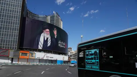 Vehículos pasan junto a una valla publicitaria que muestra un retrato del difunto líder supremo iraní, el ayatolá Alí Jamenei Vehículos pasan junto a una valla publicitaria que muestra un retrato del difunto líder supremo iraní, el ayatolá Alí Jamenei
