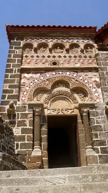 El portal rematado por un arco trilobulado y mosaicos de piedras policromadas El portal rematado por un arco trilobulado y mosaicos de piedras policromadas