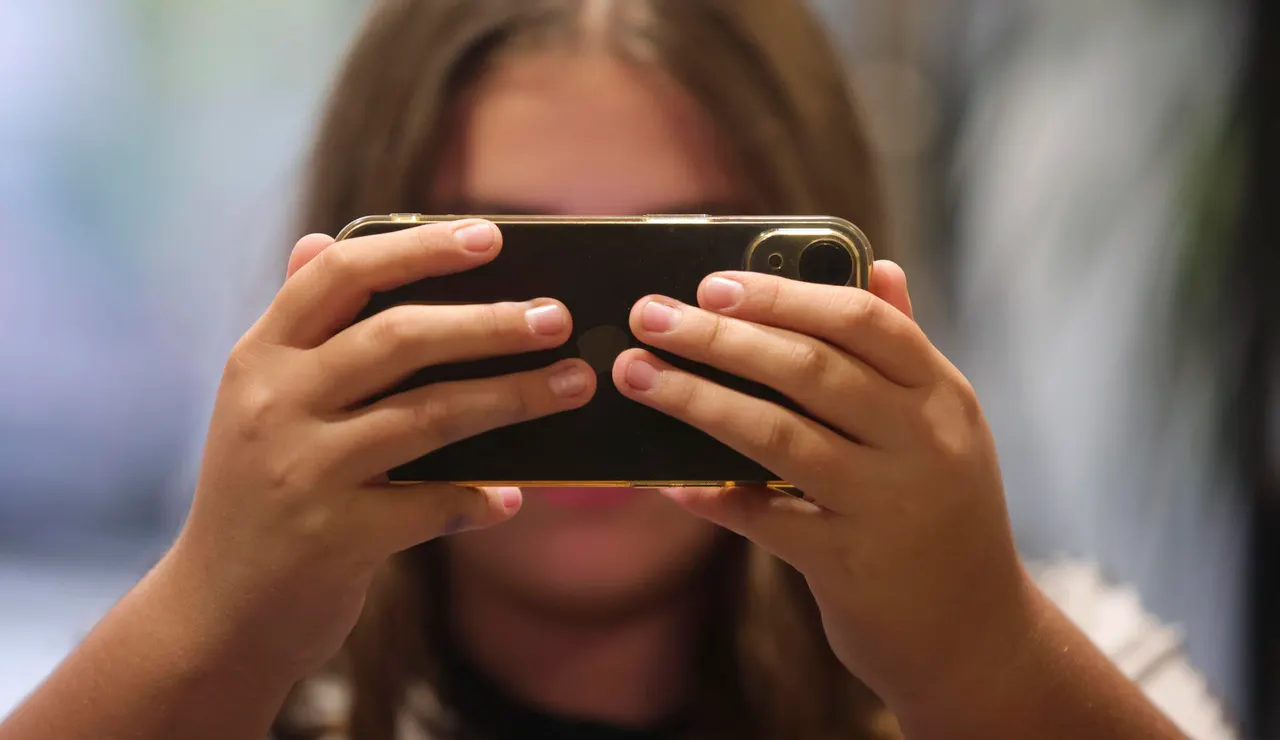 Una niña con el teléfono móvil