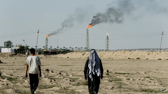 La gente camina cerca de tierras de cultivo junto al campo petrolífero de Zubair, en Irak La gente camina cerca de tierras de cultivo junto al campo petrolífero de Zubair, en Irak