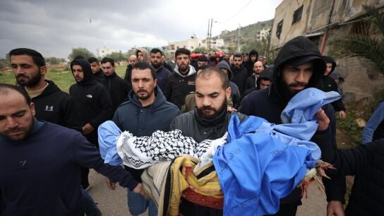 Un familiar lleva el cuerpo de un ni&ntilde;o durante el funeral de cuatro miembros de la familia palestina Bani Odeh en Tam&uacute;n