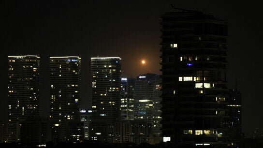 Estelas de fuego y luz cruzan el cielo nocturno de Tel Aviv mientras un interceptor israel&iacute; ataca un misil iran&iacute; en medio del conflicto entre Estados Unidos e Israel con Ir&aacute;n