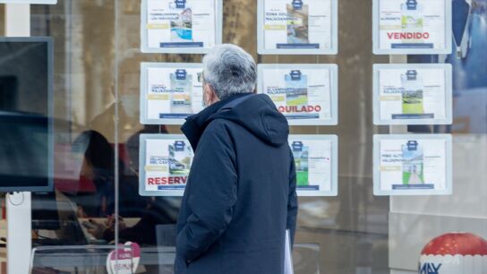 Imagen de archivo. Un hombre mira el escaparate de una inmobiliaria.