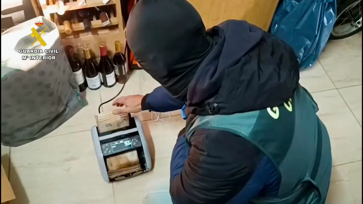 Un agente de la Guardia Civil contando con una máquina dinero incautado Un agente de la Guardia Civil contando con una máquina dinero incautado