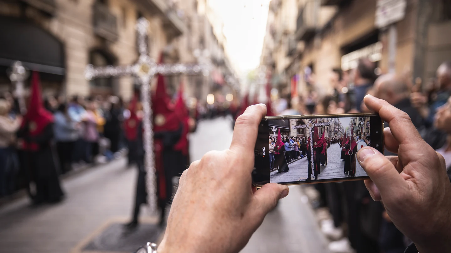 Una persona con un móvil grabando la Semana Santa de 2025 en Barcelona Una persona con un móvil grabando la Semana Santa de 2025 en Barcelona