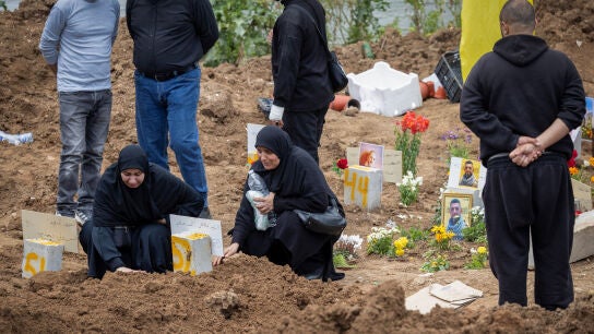Familiares guardan luto tras enterrar el cuerpo de una persona muerta en un ataque israel&iacute;, en un cementerio p&uacute;blico provisional en L&iacute;bano.
