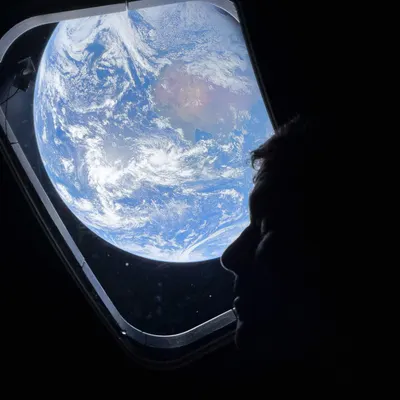 El astronauta Reid Wiseman desde la capsula Orión con la Tierra de fondo