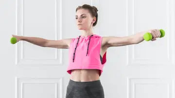 Mujer haciendo ejercicio con mancuernas Mujer haciendo ejercicio con mancuernas