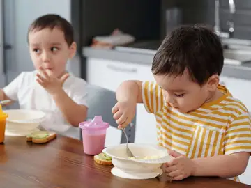 Dos niños comiendo Dos niños comiendo