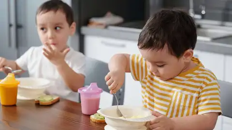 Dos niños comiendo Dos niños comiendo