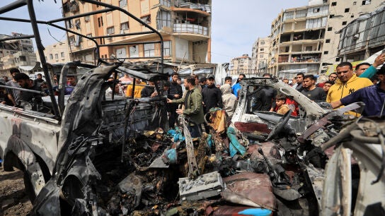 Palestinos inspeccionan los da&ntilde;os tras un ataque israel&iacute; contra un veh&iacute;culo policial en la ciudad de Gaza