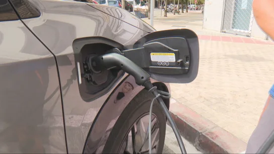 Un coche eléctrico, recargándose Un coche eléctrico, recargándose