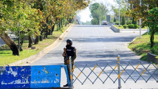 Un agente de polic&iacute;a monta guardia en un puesto de control en una carretera que conduce al Hotel Serena, sede de una posible segunda fase de las conversaciones de paz entre Estados Unidos e Ir&aacute;n, organizada por Pakist&aacute;n, en Islamabad