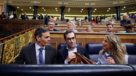 El jefe del Ejecutivo, Pedro S&aacute;nchez (i), conversa con los vicepresidentes Carlos Cuerpo y Yolanda D&iacute;az durante la sesi&oacute;n de control al Gobierno