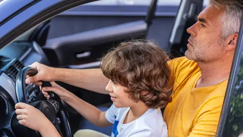 Padre dando lecciones de conducir (coche parado) a su hijo. Padre dando lecciones de conducir (coche parado) a su hijo.