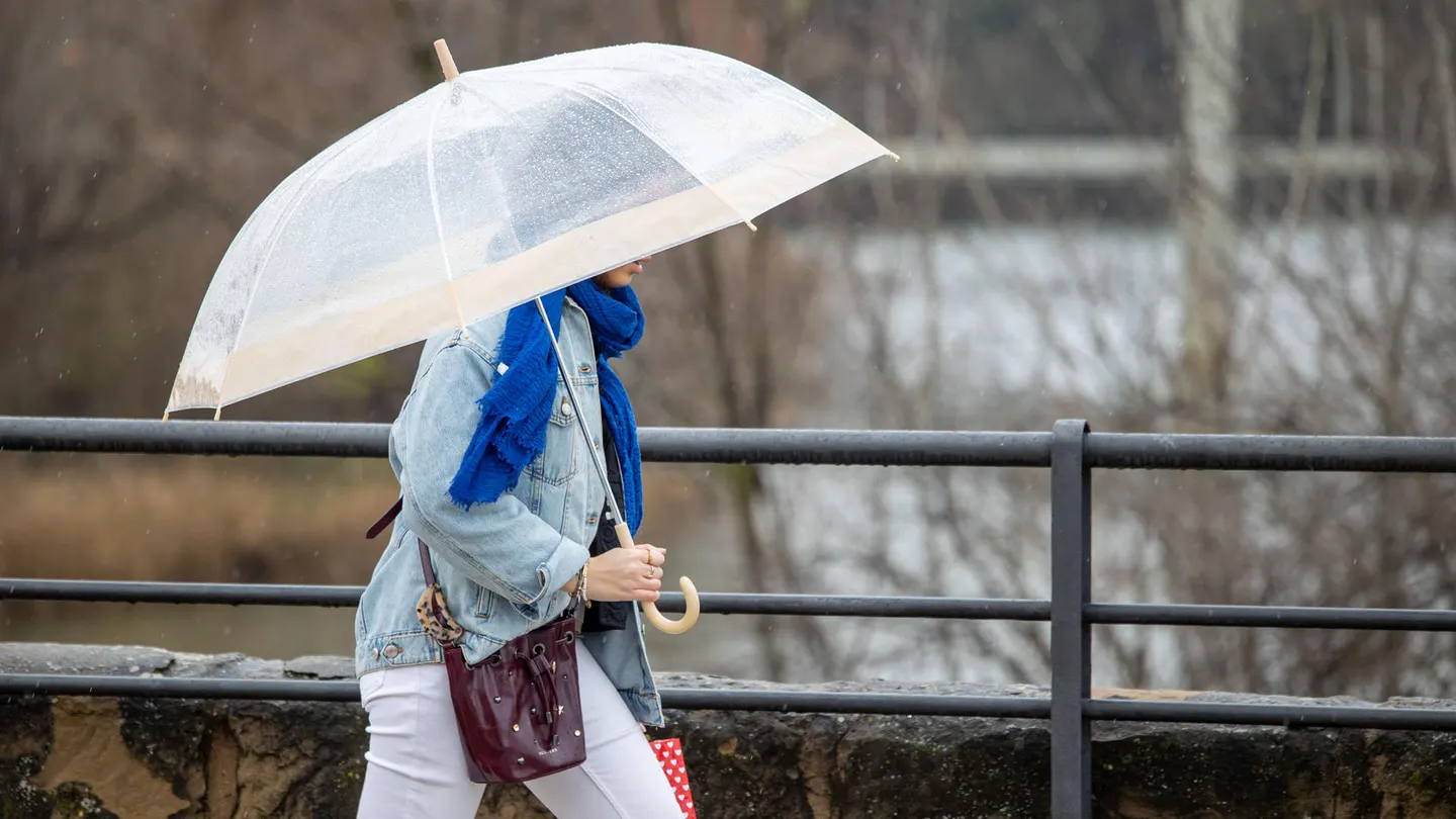 Imagen de archivo de una mujer protegiéndose de la lluvia en Logroño. Imagen de archivo de una mujer protegiéndose de la lluvia en Logroño.
