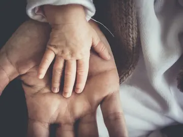 La mano de un recién nacido sobre la de su padre La mano de un recién nacido sobre la de su padre