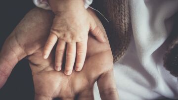 La mano de un reci&eacute;n nacido sobre la de su padre