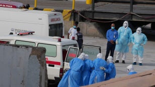 Personal sanitario con equipo de protecci&oacute;n evacua a pacientes del crucero MV Hondius a una ambulancia en un puerto de Praia, Cabo Verde