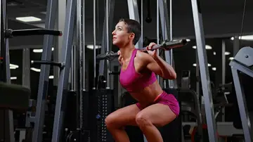 Mujer haciendo sentadillas en el gimnasio Mujer haciendo sentadillas en el gimnasio