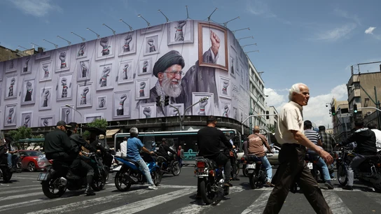 Varias personas circulan cerca de una valla con una imagen del difunto líder supremo de Irán, el ayatolá Ali Khamenei, en Teherán Varias personas circulan cerca de una valla con una imagen del difunto líder supremo de Irán, el ayatolá Ali Khamenei, en Teherán