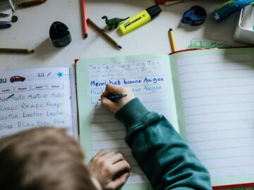 Un ni&ntilde;o escribiendo en un cuaderno
