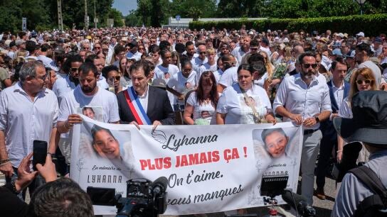 El padre de Lyhanna, Martial Bernard (2-D), y el alcalde de Fleurance, Gregory Bobbato (C), portan una pancarta con el lema "Nunca más" durante una Marcha Blanca en homenaje a Lyhanna, de 11 años, en Fleurance.