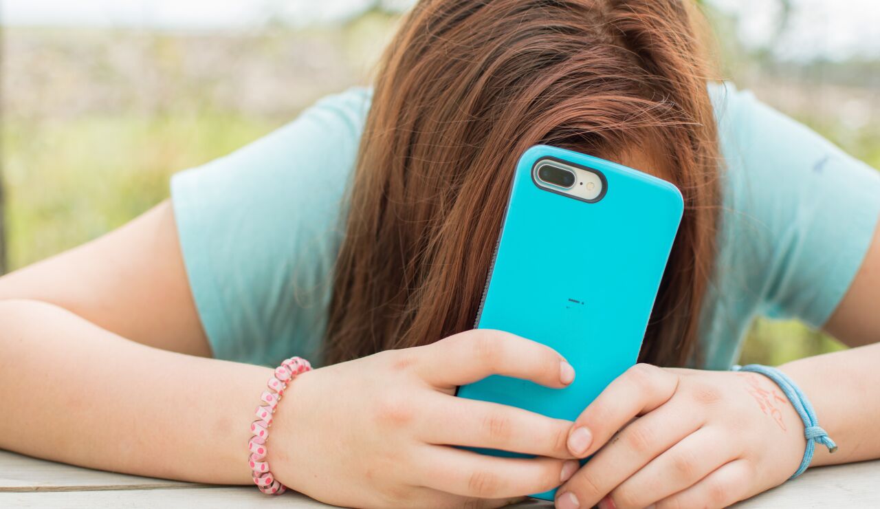 Una joven con el tel&eacute;fono m&oacute;vil