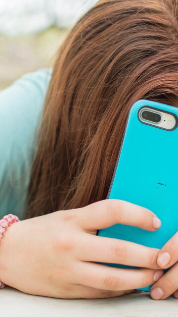 Una joven con el tel&eacute;fono m&oacute;vil