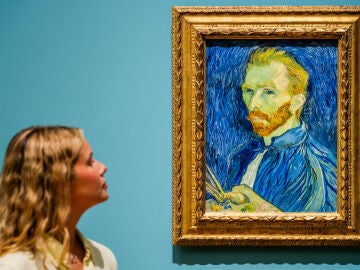 Una mujer observando el retrato de Van Gogh en un museo