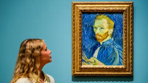Una mujer observando el retrato de Van Gogh en un museo Una mujer observando el retrato de Van Gogh en un museo