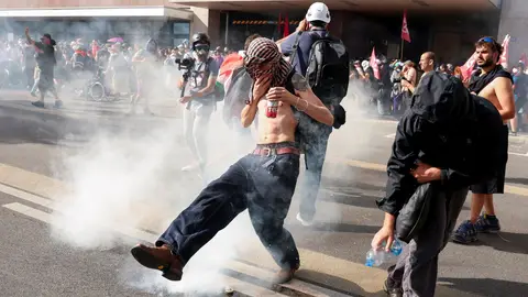 Un manifestante contra el G7 se tapa tras lanzarle un bote de gas lacrimógeno en Ginebra Un manifestante contra el G7 se tapa tras lanzarle un bote de gas lacrimógeno en Ginebra