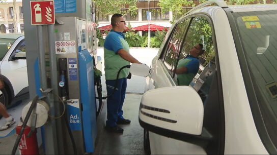 Un trabajador reposta un coche en una gasolinera