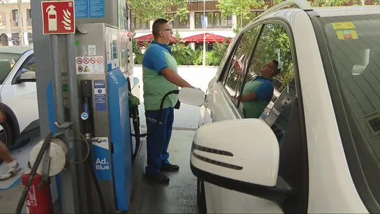 Un trabajador reposta un coche en una gasolinera Un trabajador reposta un coche en una gasolinera