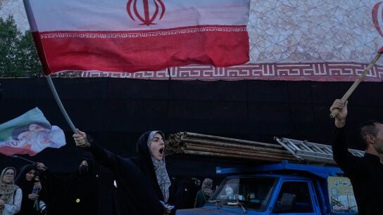 Varias personas protestan por las conversaciones entre EEUU e Ir&aacute;n mientras ondean banderas iran&iacute;es en Teher&aacute;n