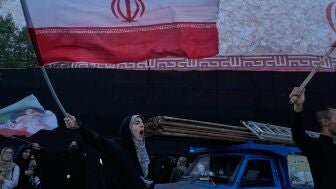 Varias personas protestan por las conversaciones entre EEUU e Ir&aacute;n mientras ondean banderas iran&iacute;es en Teher&aacute;n