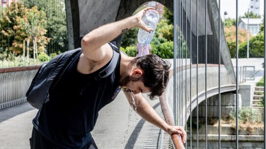 Un chico se moja la cabeza para refrescarse del calor