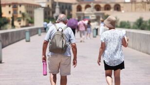 Personas caminando por el Puente Romano de C&oacute;rdoba bajo el calor.